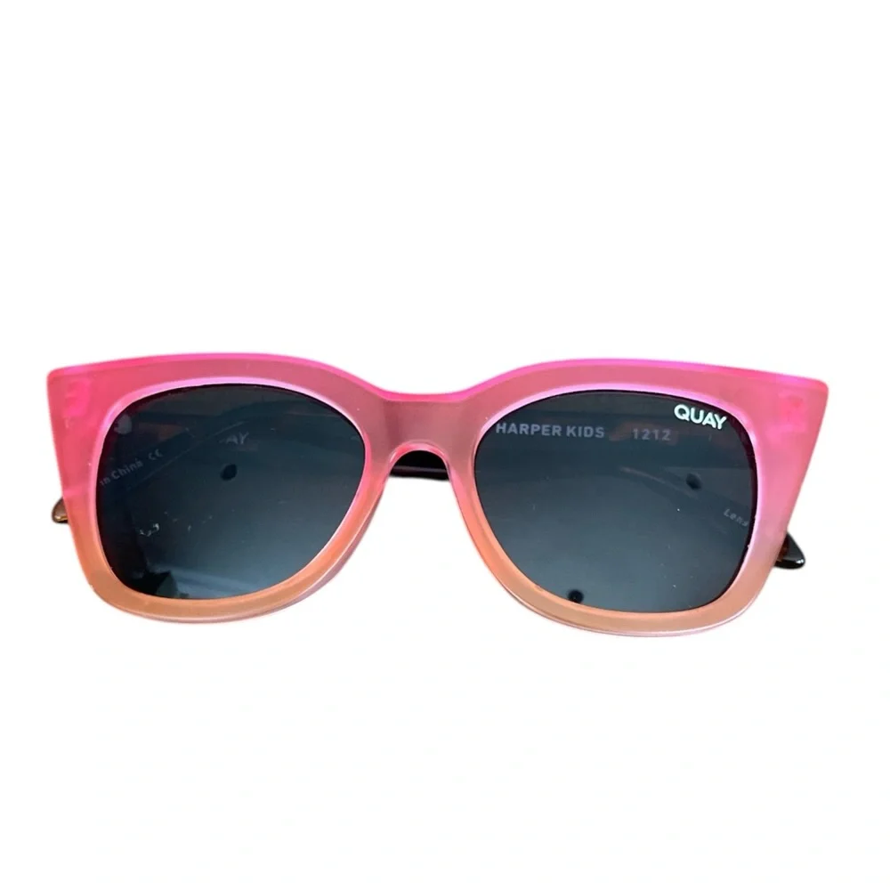 Quay Harper Kids cat-eye sunglasses with coral pink and smoke lenses.